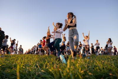 Students gather on Horsebarn Hill for the UConn Rec Center’s Sunset Yoga program on Sept. 2, 2022. (Sydney Herdle/UConn Photo)