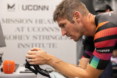 Professional triathlete Jon Fecik rides a stationary bike during his workout in the Korey Stringer Institute’s Mission Heat Lab on Sept. 8, 2022. (Sydney Herdle/UConn Photo)