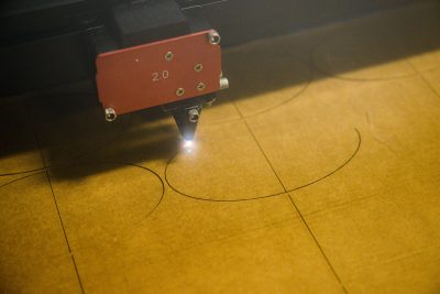 A CNC laser cutter is used at the Proof of Concept Center (POCC) to cut cardboard-backed felt to help the Ballard Museum and Institute of Puppetry build puppets for the "Feel your Best Self" project at the Innovation Partnership Building on July 20, 2022. (Peter Morenus/UConn Photo)