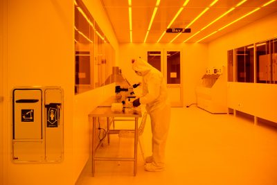 Mustafa Yavuz, Institute for Material Science clean room manager, looks though a microscope in a clean room at the Science1 Research Center on June 26, 2023. (Peter Morenus/UConn Photo)