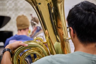 Janet Kim, assistant professor of music, leads a wind ensemble rehearsal at the Music Building