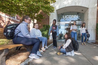 A group of master’s students talking outside the School of Social Work (SSW) building.  Sept. 15, 2022. (Sean Flynn/UConn Photo)